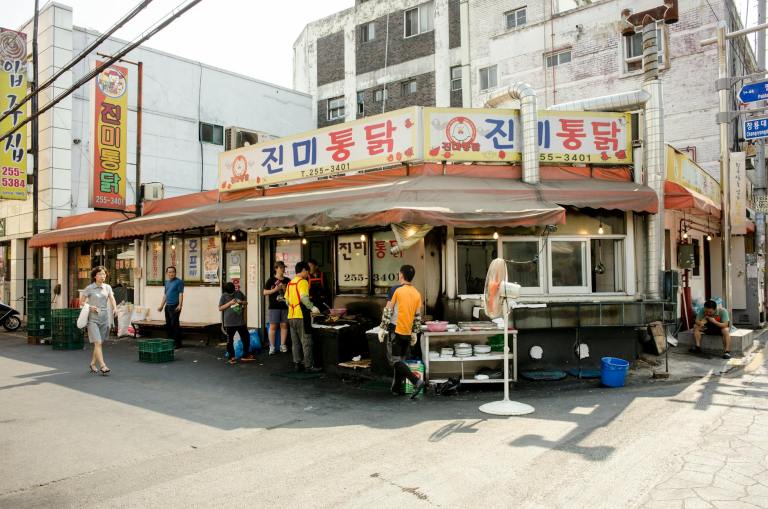 people relaxing by small restaurant in korea