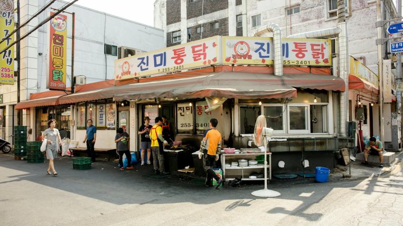 people relaxing by small restaurant in korea